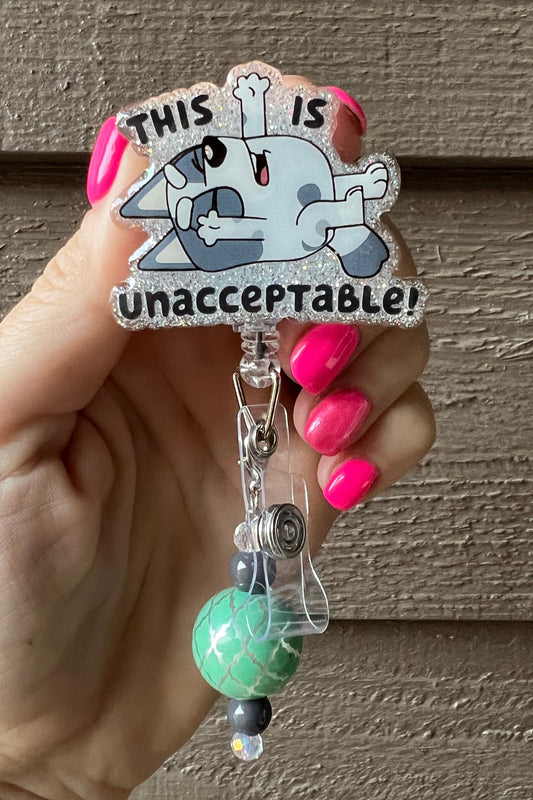 Muffin from bluey with the phrase "This is unacceptable!" over soft glitter with a mint and grey dangle.