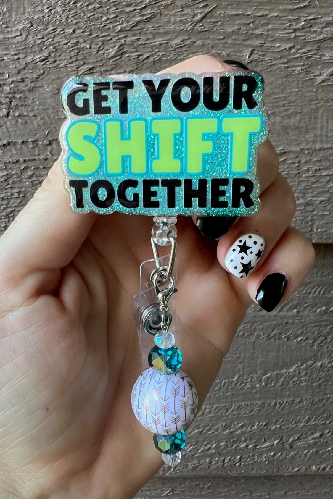 Hand holding aqua badge reel with the text "Get your SHIFT together" with coordinating badge bling.