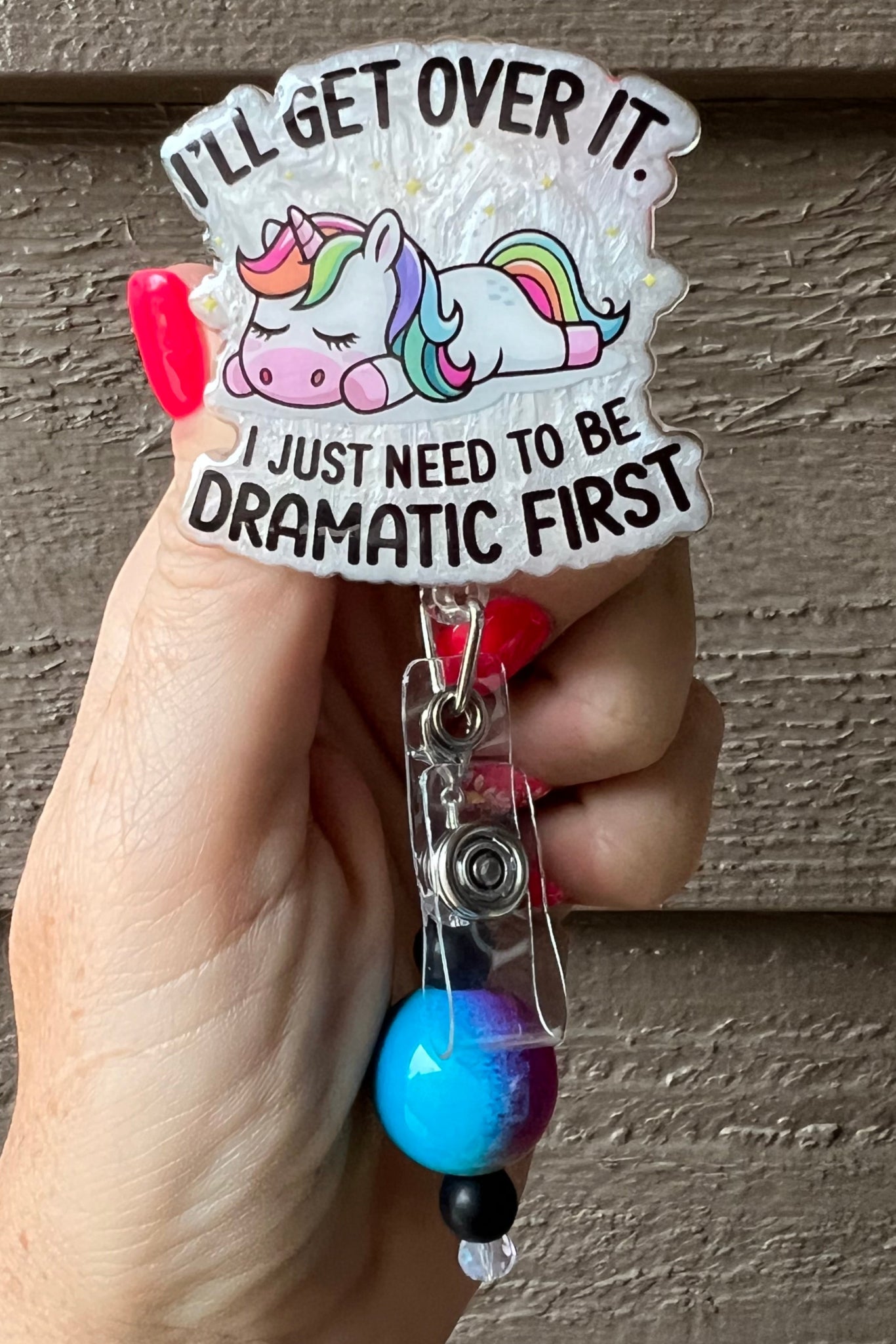 Sleepy Unicorn badge reel that says "I'll get over it. I just need to be dramatic first" on pearl background with coordinating badge bling.
