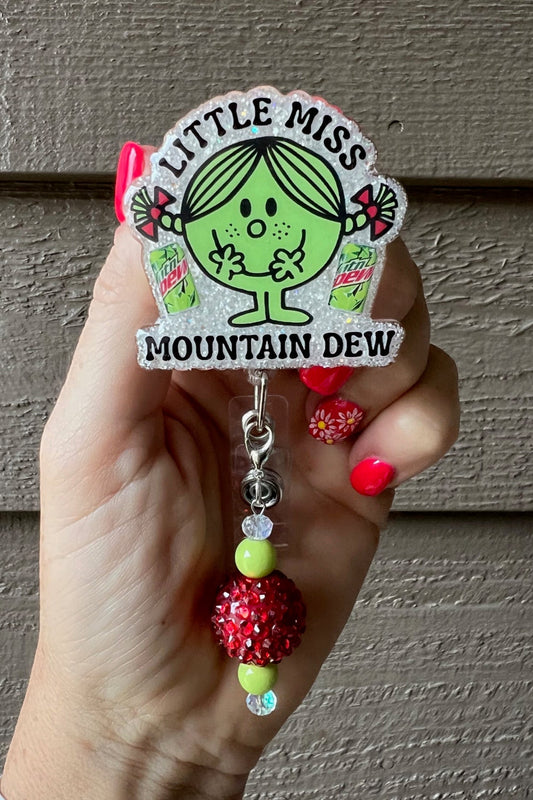 Little Miss Mountain Dew Badge Reel on soft white glitter with coordinating badge bling.