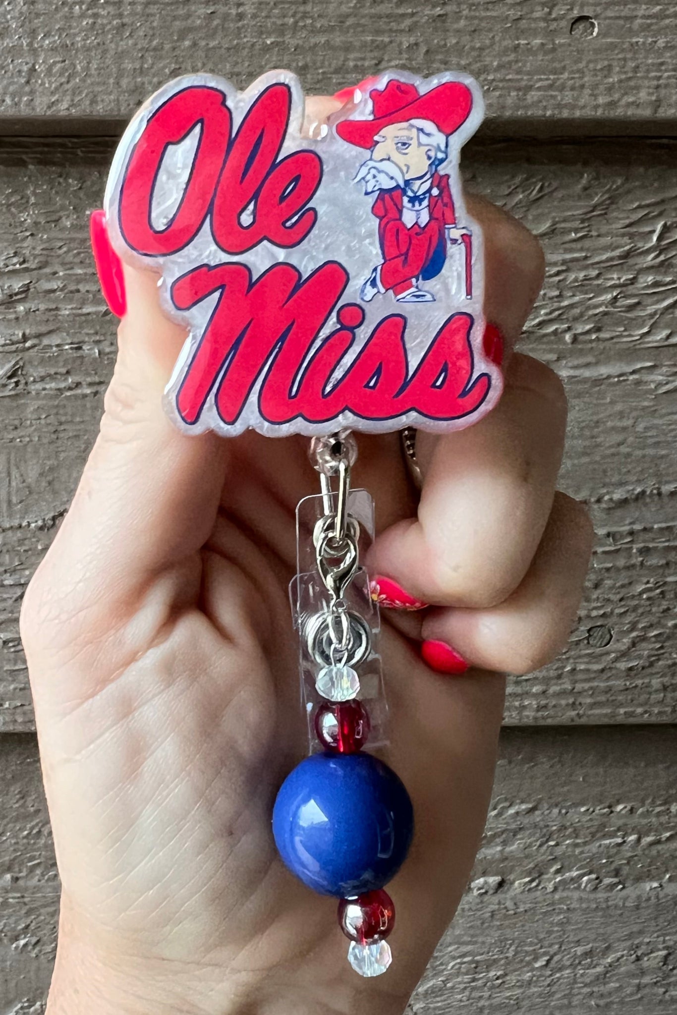 Ole Miss Badge Reel on white pearl background with coordinating badge bling.