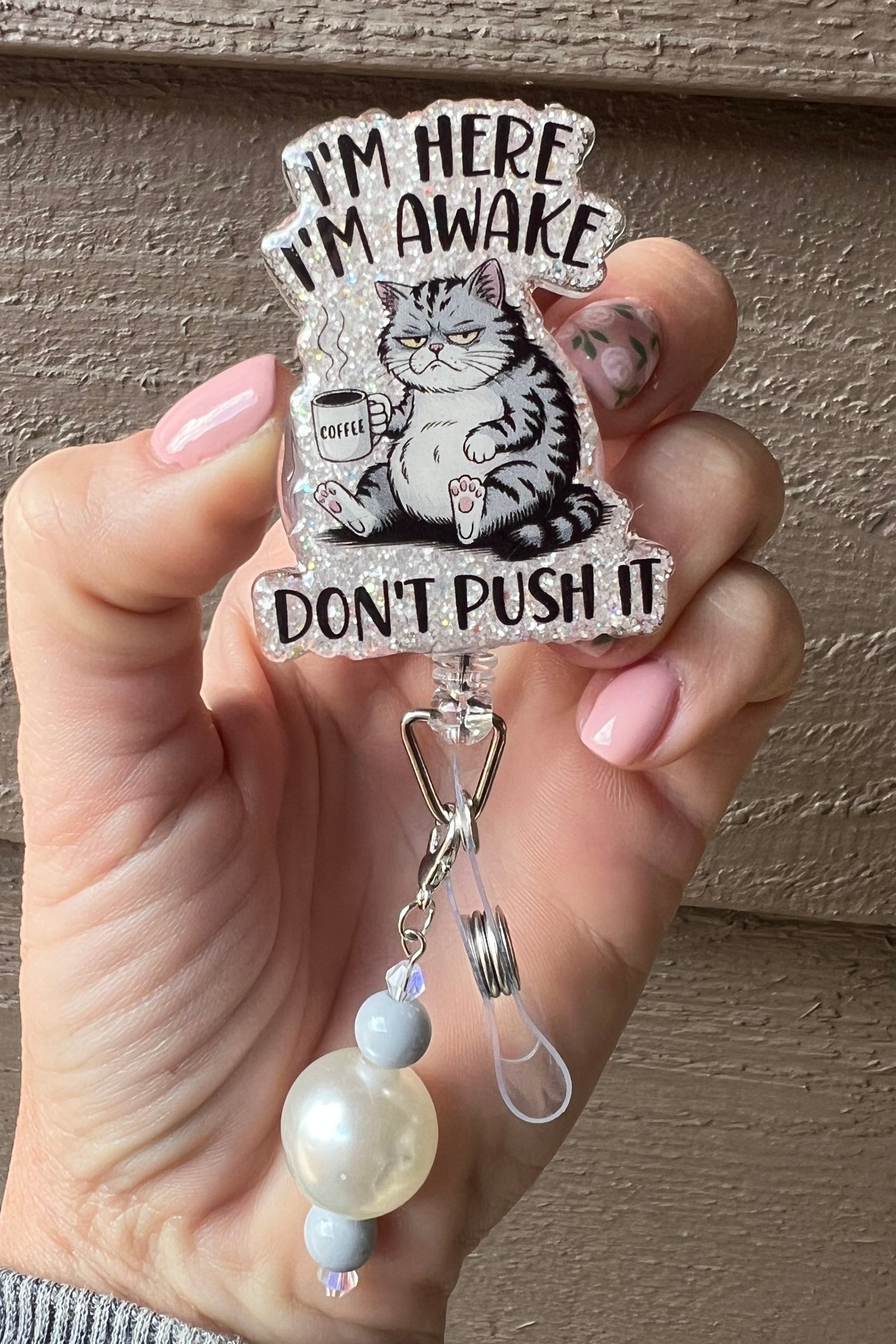 Funny cat badge reel with glitter border and coffee cup, reading "I'm here, I'm Awake, don't push it," paired with coordinating badge bling.