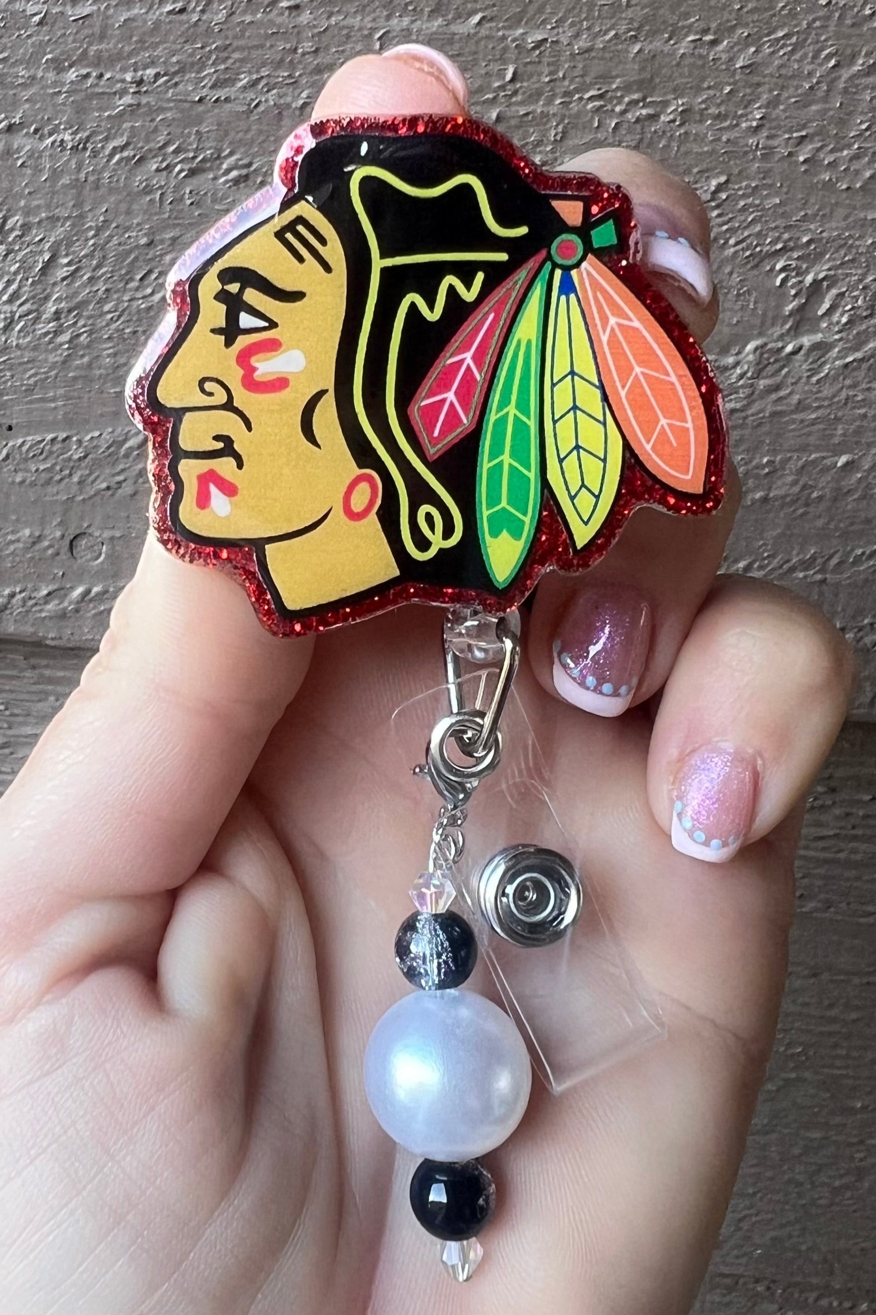 Blackhawks badge reel with black and white beaded dangle and red glittery border