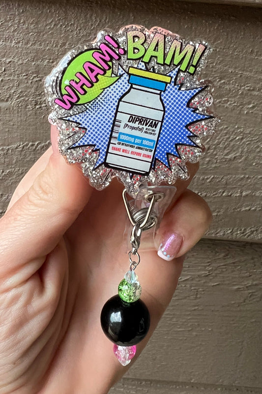 A comic-style badge reel with a Propofol (Diprivan) vial in the center and "WHAM! BAM!" text and coordinating badge bling.
