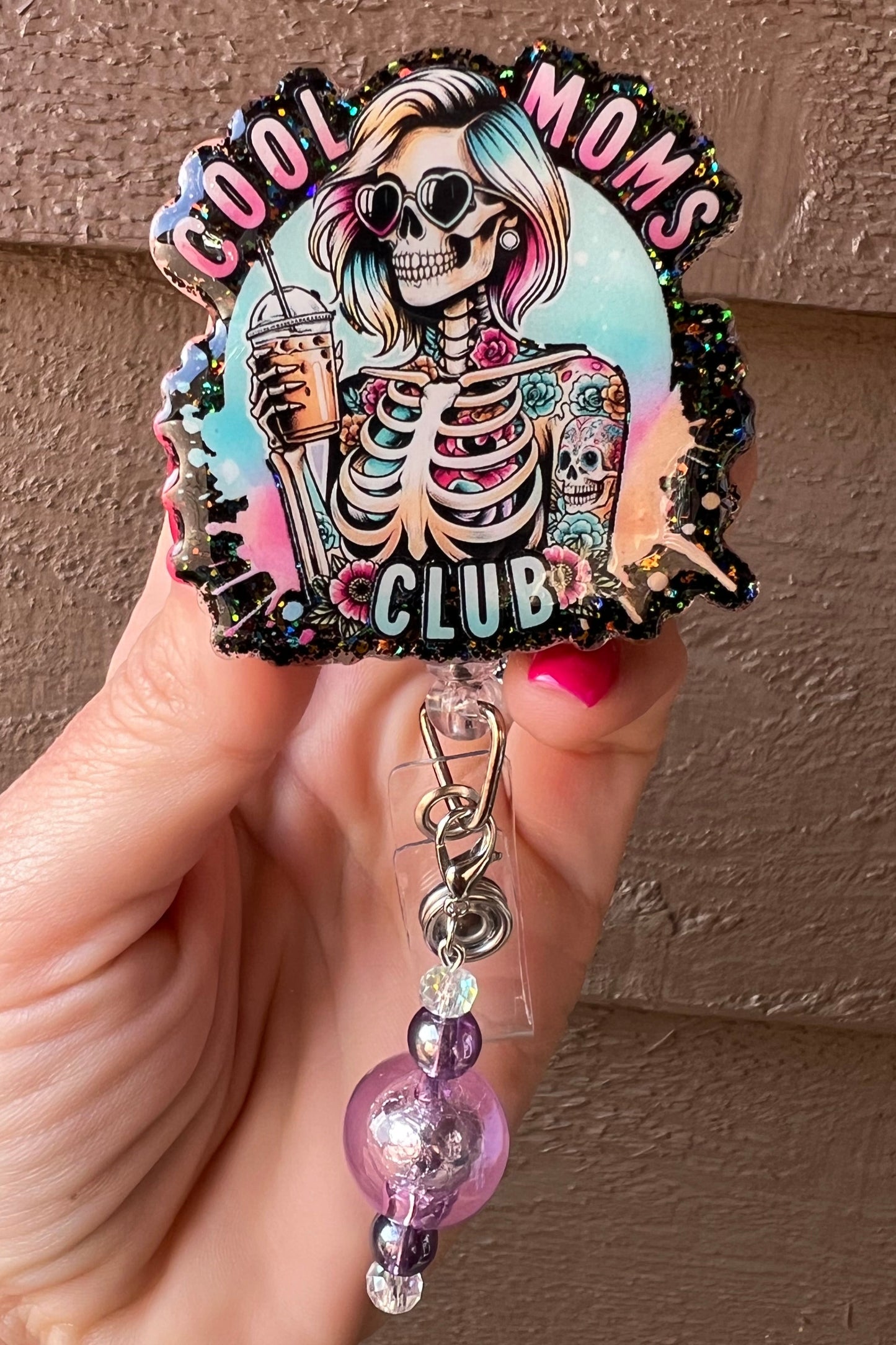 Cool Moms Club badge reel with skeleton with rainbow hair, tattoos, and an iced coffee with coordinating badge bling.
