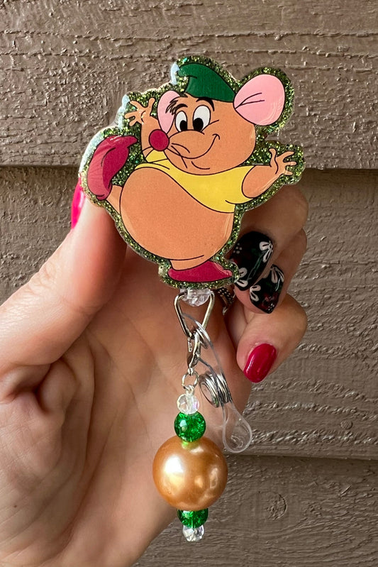 Gus Gus badge reel with glittery green border and green and gold dangle.