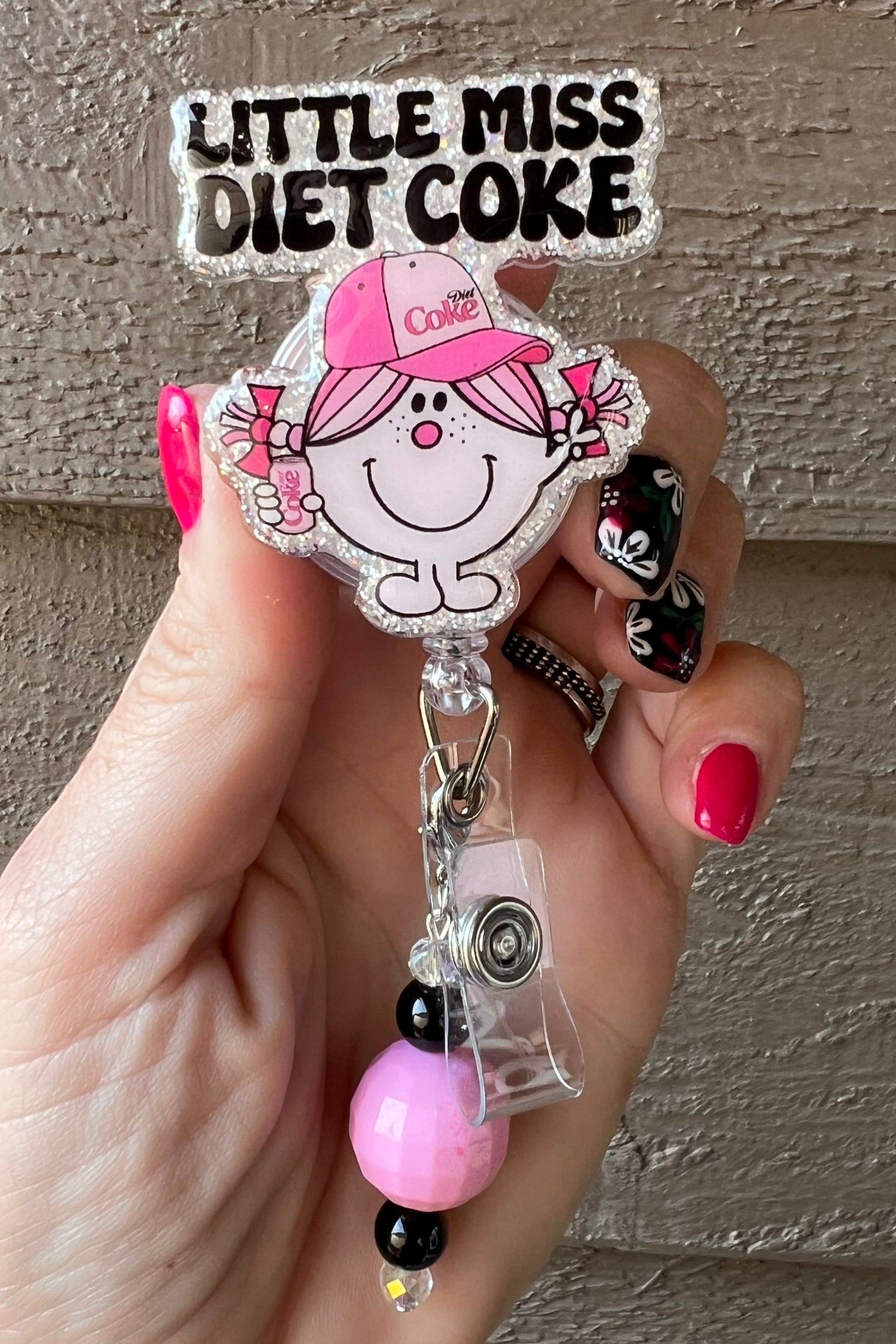 Glittery Little Miss Diet Coke Badge Reel with pink hat and black/pink beaded dangle.
