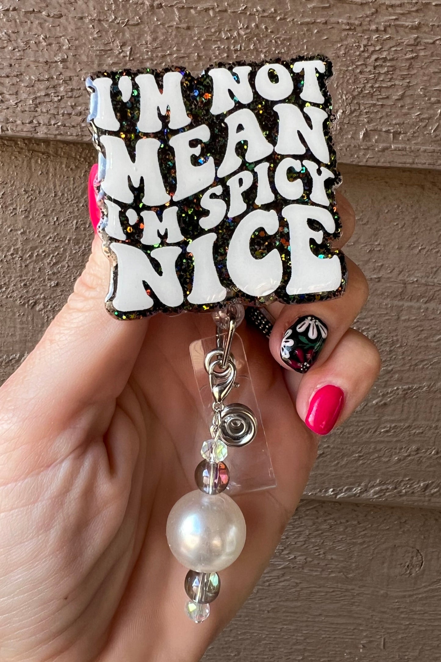 Badge Reel that states "I'm Not Mean I'm Spicy Nice" on Black holographic glitter with coordinating badge bling.