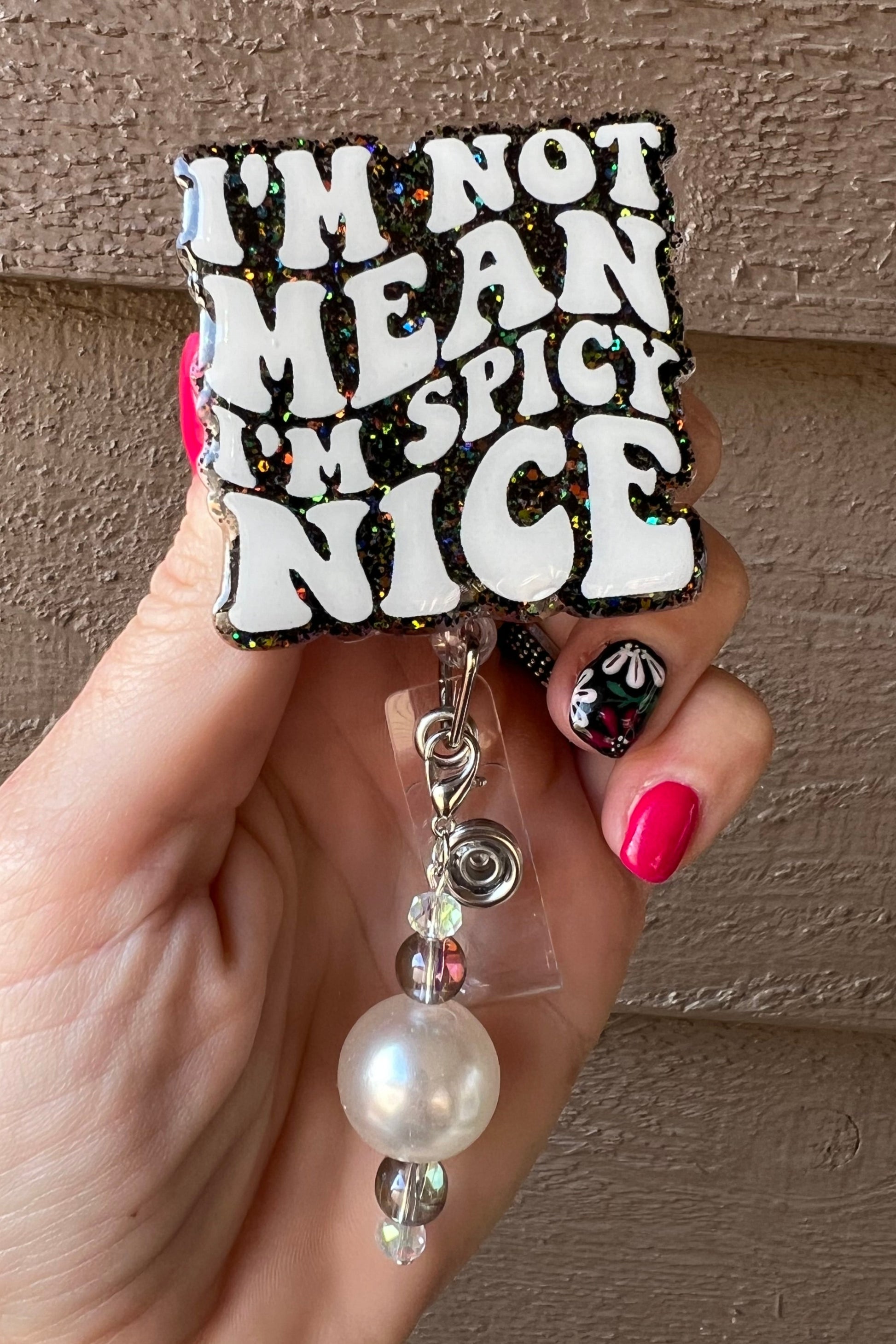Badge Reel that states "I'm Not Mean I'm Spicy Nice" on Black holographic glitter with coordinating badge bling.