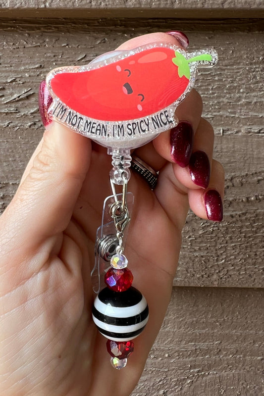 Smiling Chili Pepper Badge Reel with the text "I'm Not Mean, I'm Spicy Nice" with a coordinating badge bling.