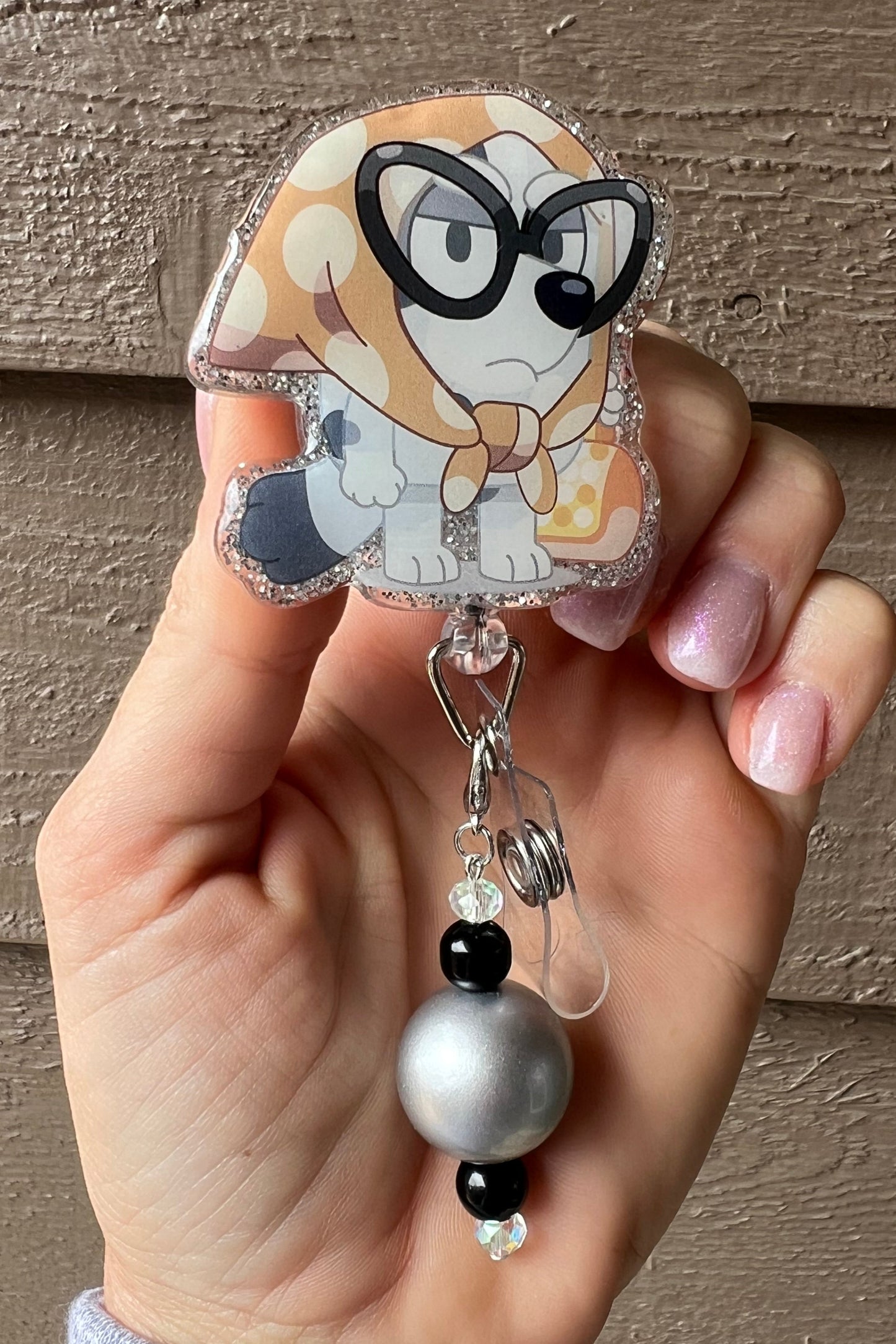Badge reel featuring Muffin as Granny Gladys from Bluey, with glitter border and silver/black beaded dangle