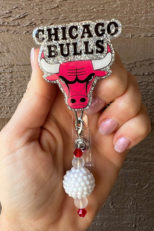 Chicago Bulls badge reel with silver glitter behind the logo and a white and red beaded dangle.