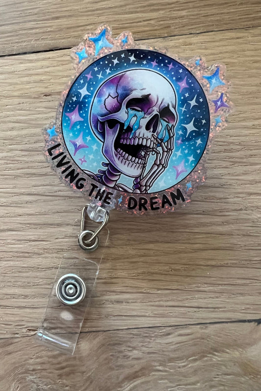 Crying skeleton badge reel with stars and the words “Living the Dream” in cosmic colors