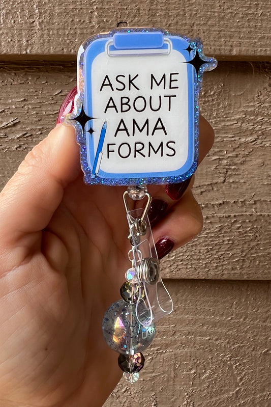 A glittery blue clipboard-shaped badge reel with the phrase “Ask Me About AMA Forms,” decorated with holographic and black beads. Perfect for medical professionals and healthcare workers.